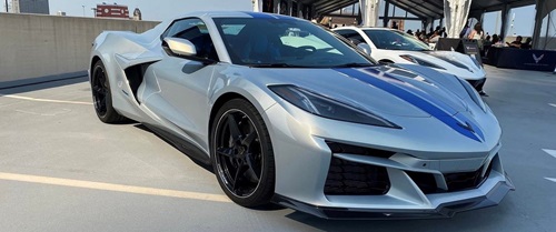 A silver Corvette with a blue stripe