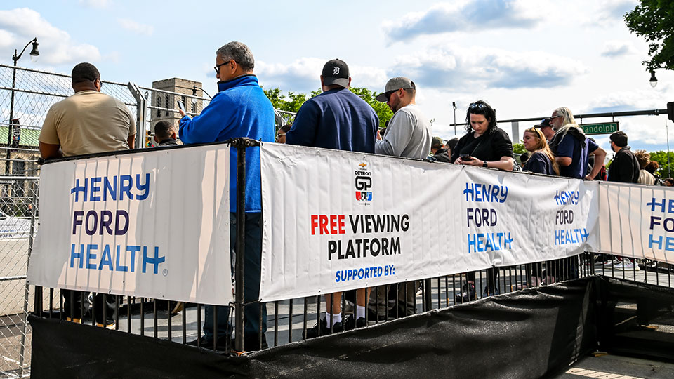 Fans stand in a free viewing pavilion